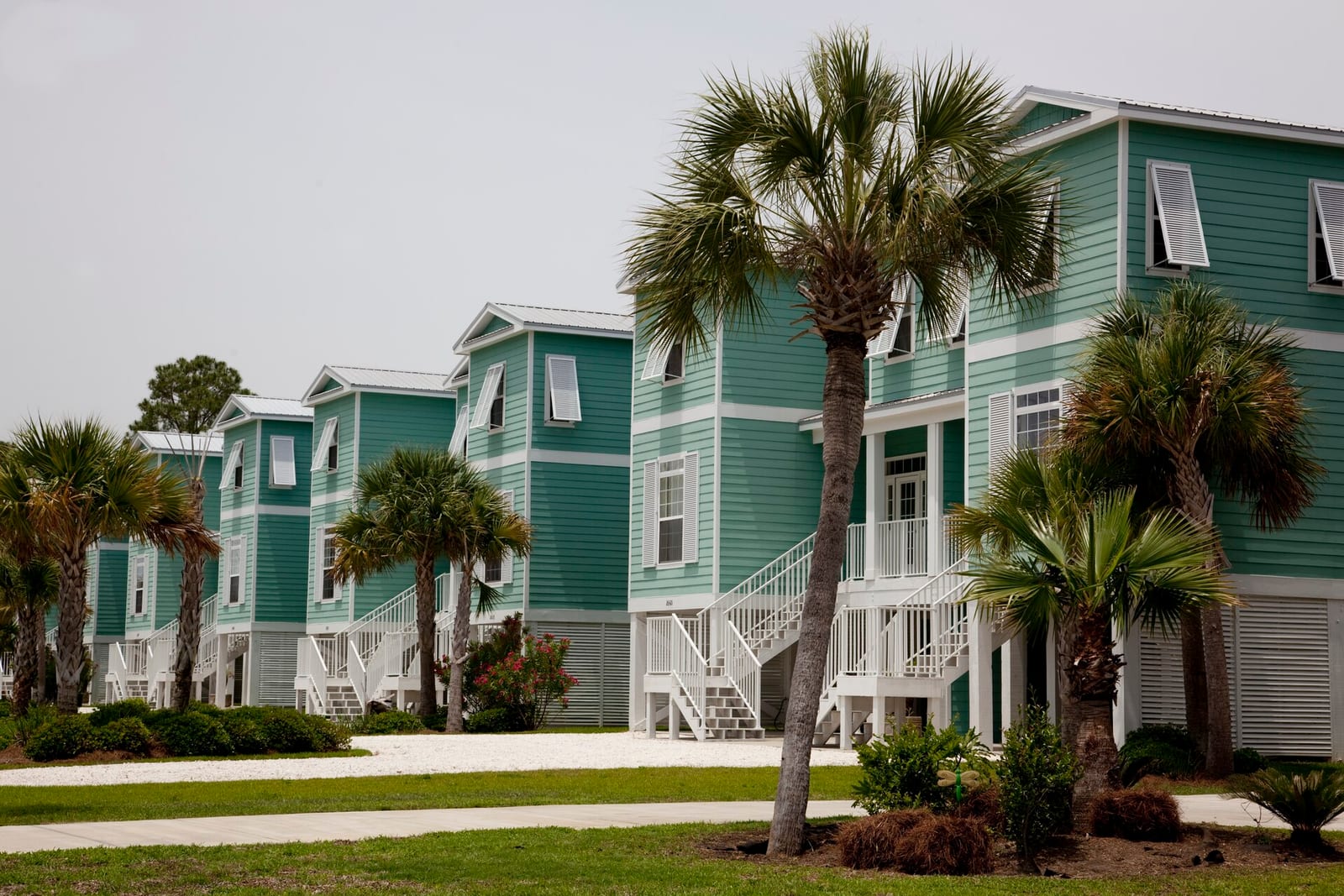 Row of seafoam coastal beach houses with palms
