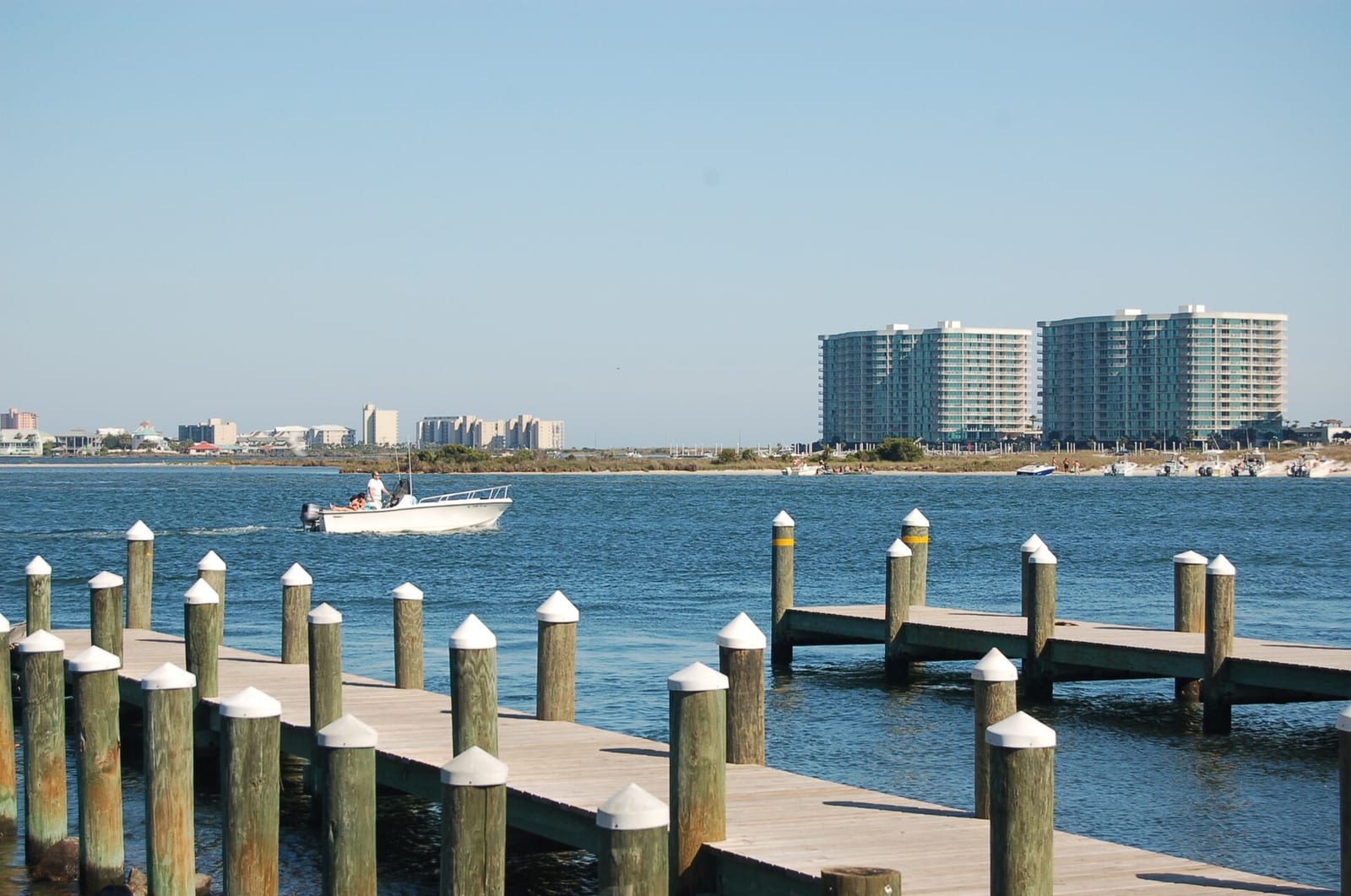 Boat heading out past the piers and condo towers of Orange Beach, Alabama
