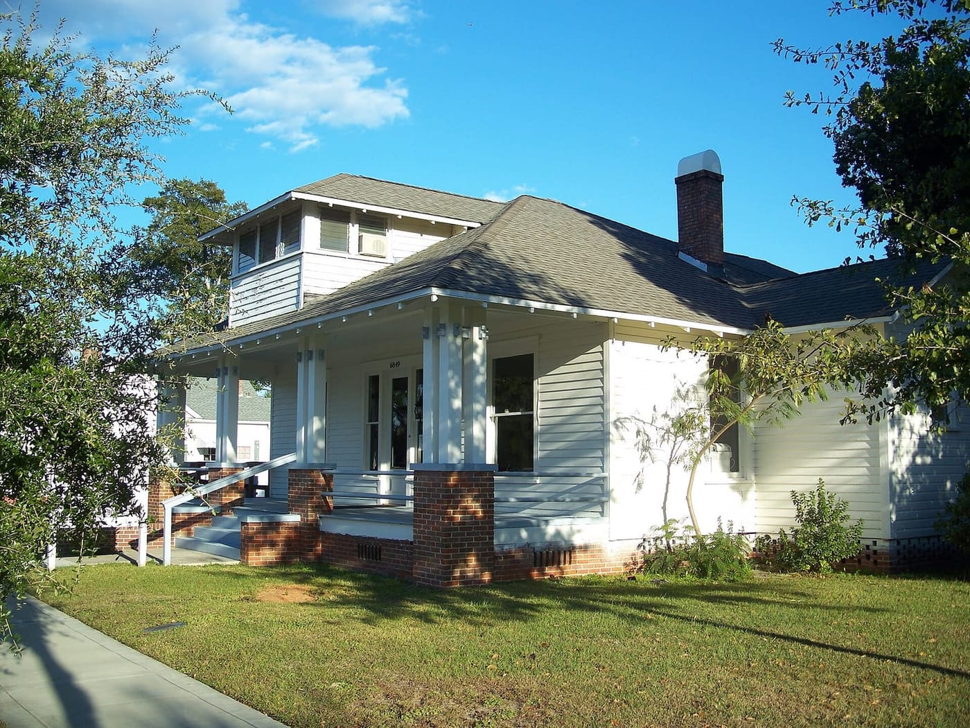 White bungalow with a brick-pier front porch in the Milton Historic District